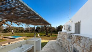 Une salle de bain extérieure moderne avec un mur en pierre, une piscine et une pergola.