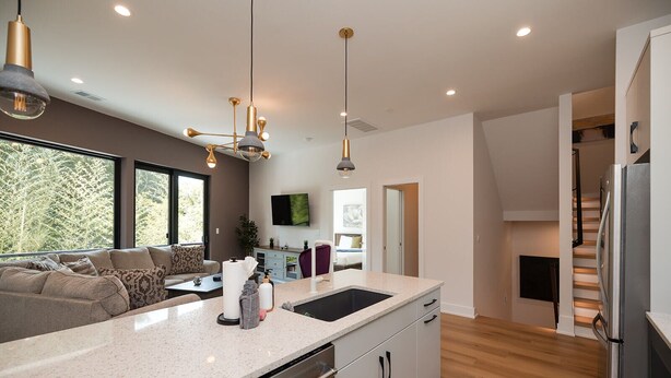 A modern kitchen with a large island, built-in appliances, and a dining area with a sofa. - Turf ROOFTOP + Sleeps Up to 16 If Renting Multiple Units! Unit B (Wilmington)