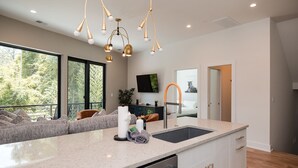 A modern kitchen with a large island, a built-in dishwasher, and a pendant light fixture. - Turf ROOFTOP w Games and more in Heart of Wilmington! Rent Multiple or One Unit! Unit C (Wilmington)