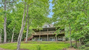 A two-story wooden cabin surrounded by dense trees. - 3 Bedrooms, 1 Flex Room, 4 Bathrooms!  Come Visit 'Lake-A-Licious'! (Huddleston)