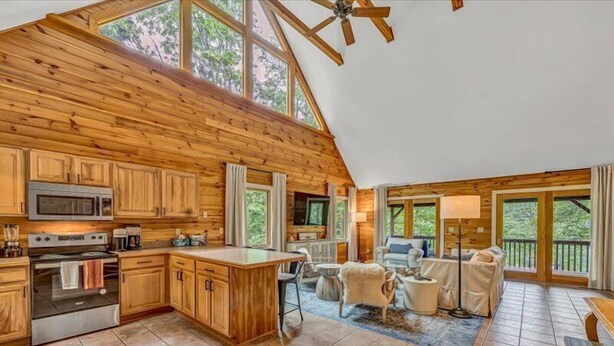A spacious cabin with a kitchen, dining area, and living room, featuring wooden walls and large windows. - 3 Bedrooms, 1 Flex Room, 4 Bathrooms!  Come Visit 'Lake-A-Licious'! (Huddleston)