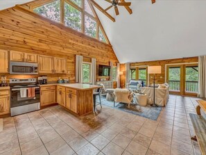 A spacious cabin with a kitchen, dining area, and living room, featuring wooden walls and large windows. - 3 Bedrooms, 1 Flex Room, 4 Bathrooms!  Visit LAKE-A-LICIOUS! (Huddleston)
