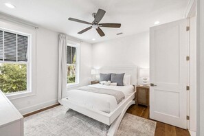 A bedroom with a white bed, a ceiling fan, a window with blinds, and a door. - Sleeps 18! Private Pool, Hot Tub, LSV/Golf Cart, Bikes, & Pet Friendly! (Santa Rosa Beach)