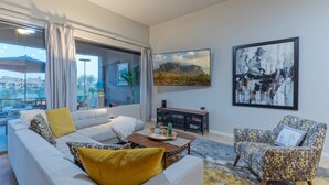 A modern living room with a sofa, armchair, coffee table, and artwork on the walls. - Golden Golf & Mt VIEWS, Golfers/Hikers Paradise, Comm Htd Salt POOL & Spa (Gold Canyon)