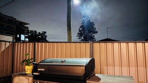 Grilli, jossa on ohjauspaneeli ja keltainen pata kivitasolla.