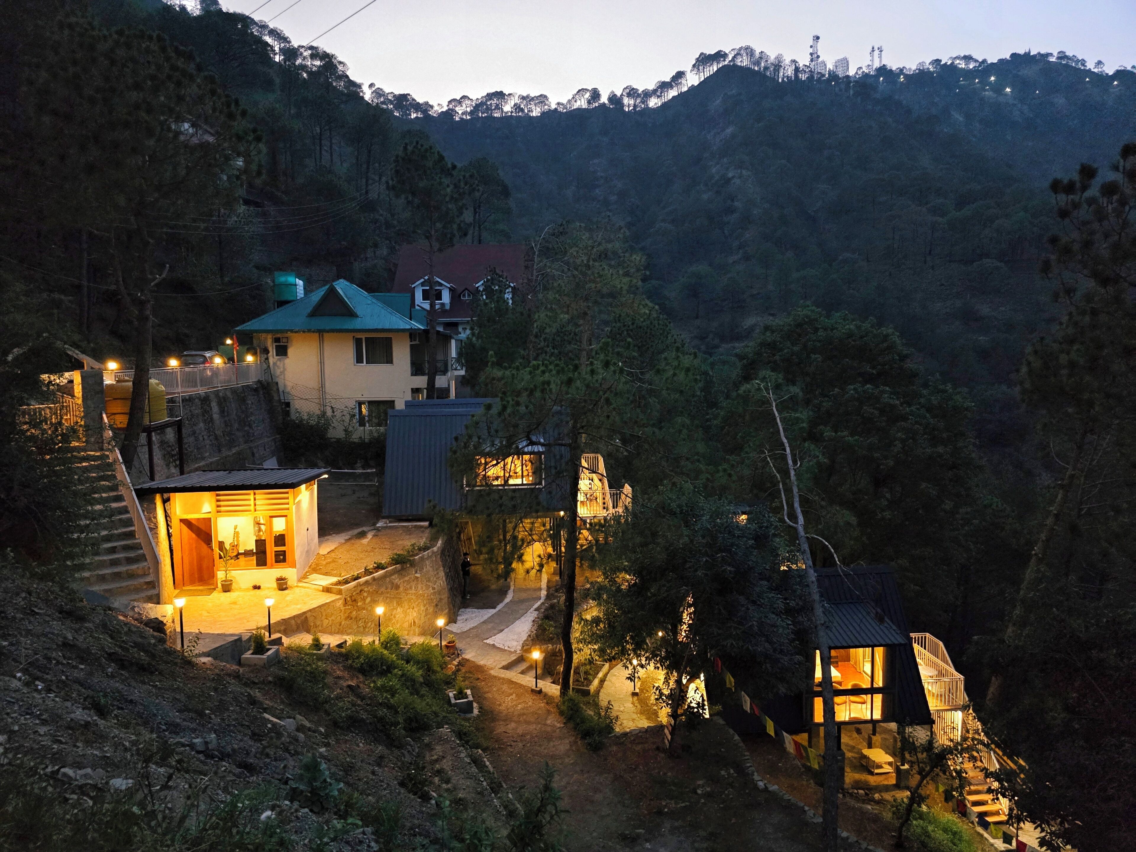 Una propiedad en una ladera con un edificio principal y otra estructura más pequeña.