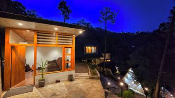Una casa moderna con recepción, camino de piedra y vistas del paisaje circundante.