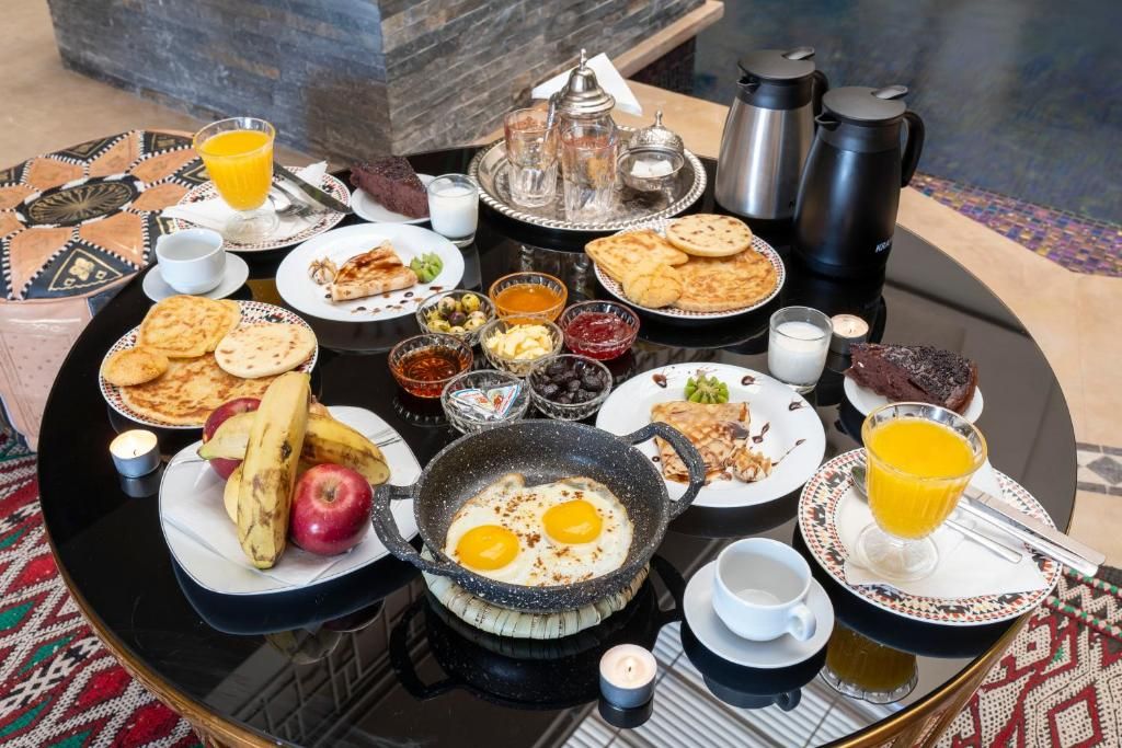 A breakfast buffet with various dishes, drinks, and condiments on a round table.