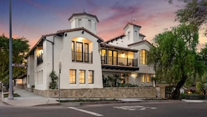 A two-story house with a stone foundation, multiple windows, and a balcony. - Casa Riviera 1 - Boutique Suites (Santa Barbara)