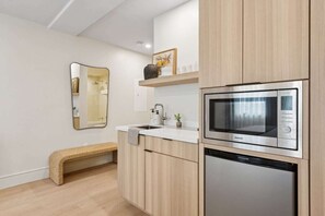 Una cocina moderna con armarios de madera, un microondas integrado y un lavavajillas.