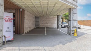 A hotel entrance with a 'Grand Open' sign, a covered walkway, and a parking area. - ANYANG IT CENTRO HOTEL (Anyang)