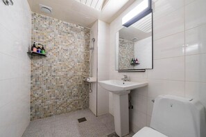 Ein Badezimmer mit Dusche, Waschbecken und Toilette.