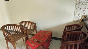 Un comedor con cuatro sillas de madera y una mesa pequeña cubierta con un mantel rojo.
