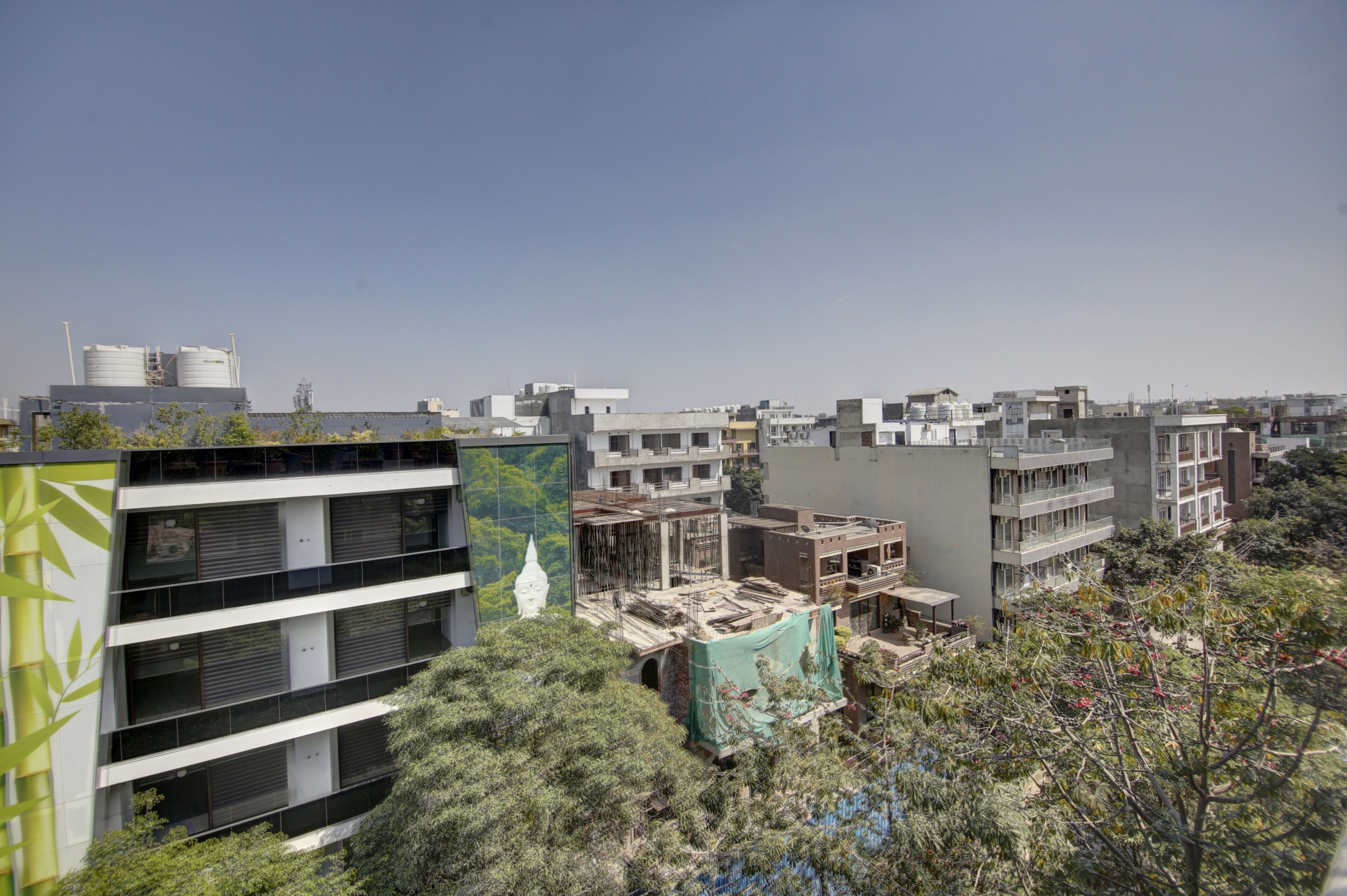Un immeuble à plusieurs étages doté de balcons, d’un jardin sur le toit et d’une architecture moderne.