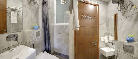 Un baño moderno con ducha, inodoro, lavamanos y una puerta de madera.