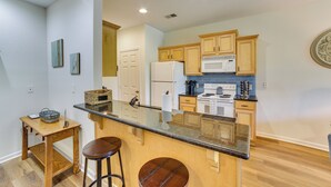A kitchen with wooden cabinets, a granite countertop, a refrigerator, and a microwave. - Game & Movie Rooms! Unit 4 Mi to Branson Landing (Branson)