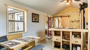 A cozy kitchen with wooden furniture, a dining area, and a view through a window. - Fishing & Views: 'river Paradise' in Dubois! (Dubois)