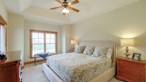A bedroom with a large bed, a ceiling fan, a nightstand with a lamp, and a window with blinds. - Mountain Condo 2 Mi to Dtwn Banner Elk w/ Views! (Banner Elk)