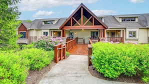 A two-story building with a prominent gable roof, a covered front porch, and a concrete pathway leading to the entrance. - Mountain Condo 2 Mi to Dtwn Banner Elk w/ Views! (Banner Elk)