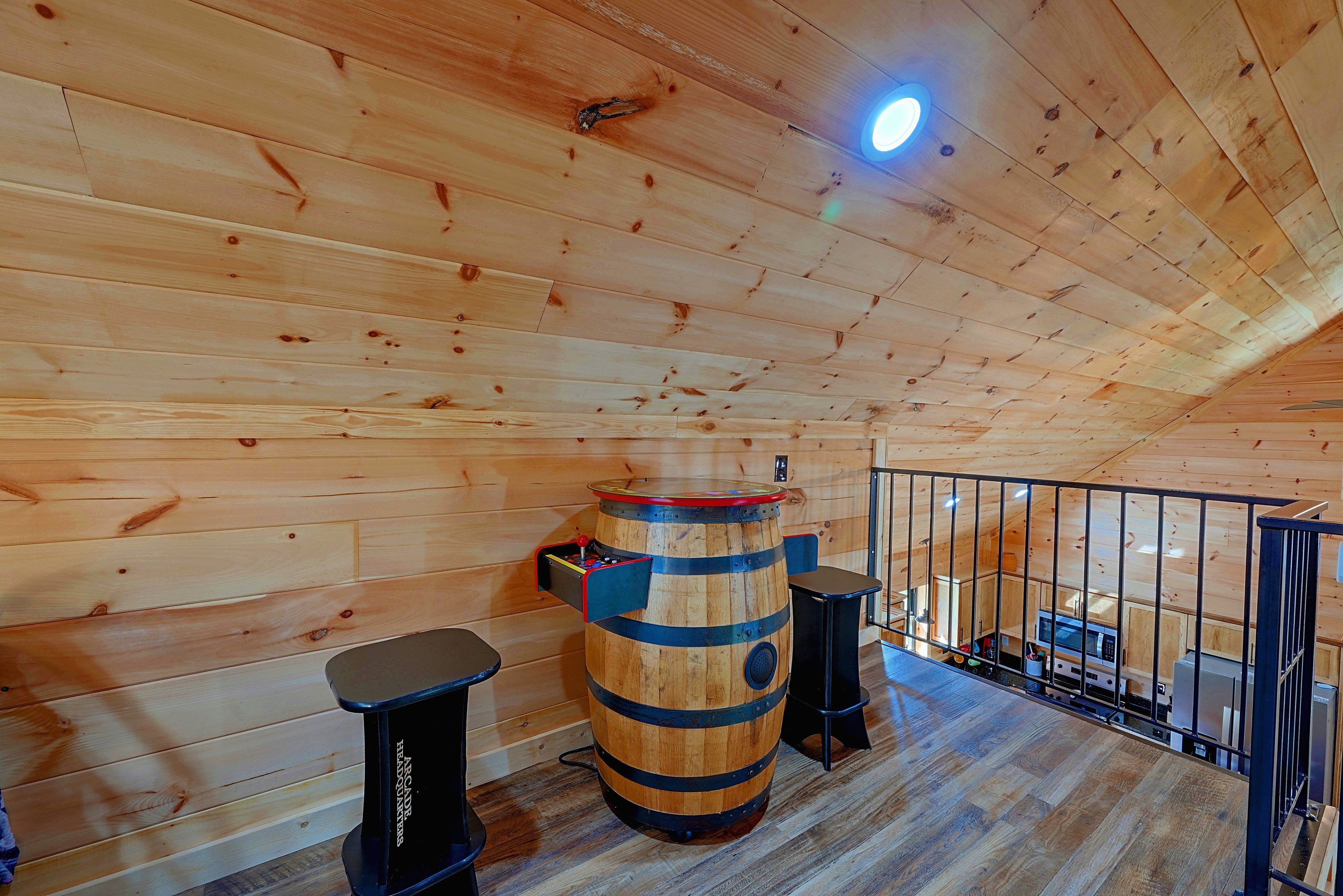 A wooden interior with a large barrel, a small table, and a black stool.