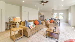 A spacious living room with a large sofa, coffee table, and a ceiling fan. - Home 21 Mi to Glacier Nat'l Park: Boat, Fish, Hike (Columbia Falls)