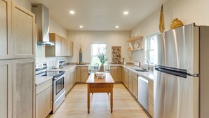A modern kitchen with stainless steel appliances, wooden cabinets, and a central island. - Home 21 Mi to Glacier Nat'l Park: Boat, Fish, Hike (Columbia Falls)