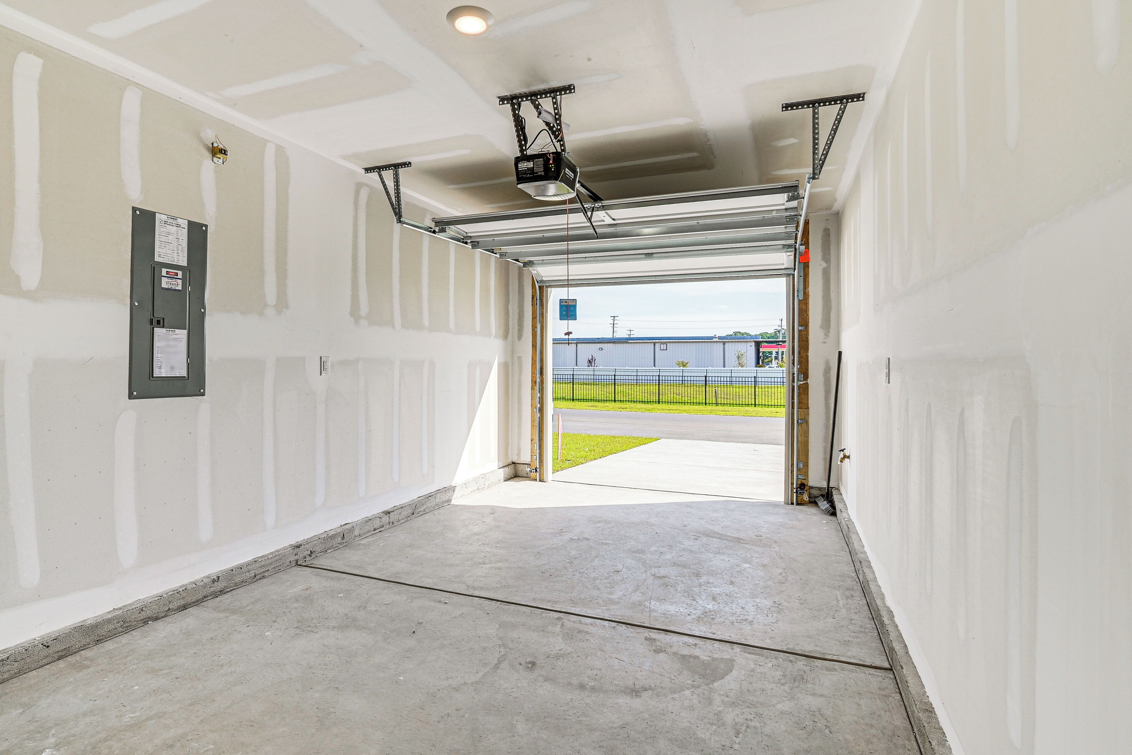 A hallway with a garage door leading to an outdoor area.