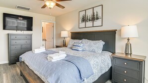 A bedroom with a bed, bedside tables, a TV, and a ceiling fan. - 3 Mi to Shore: Family Townhome in Surfside Beach (Surfside Beach)