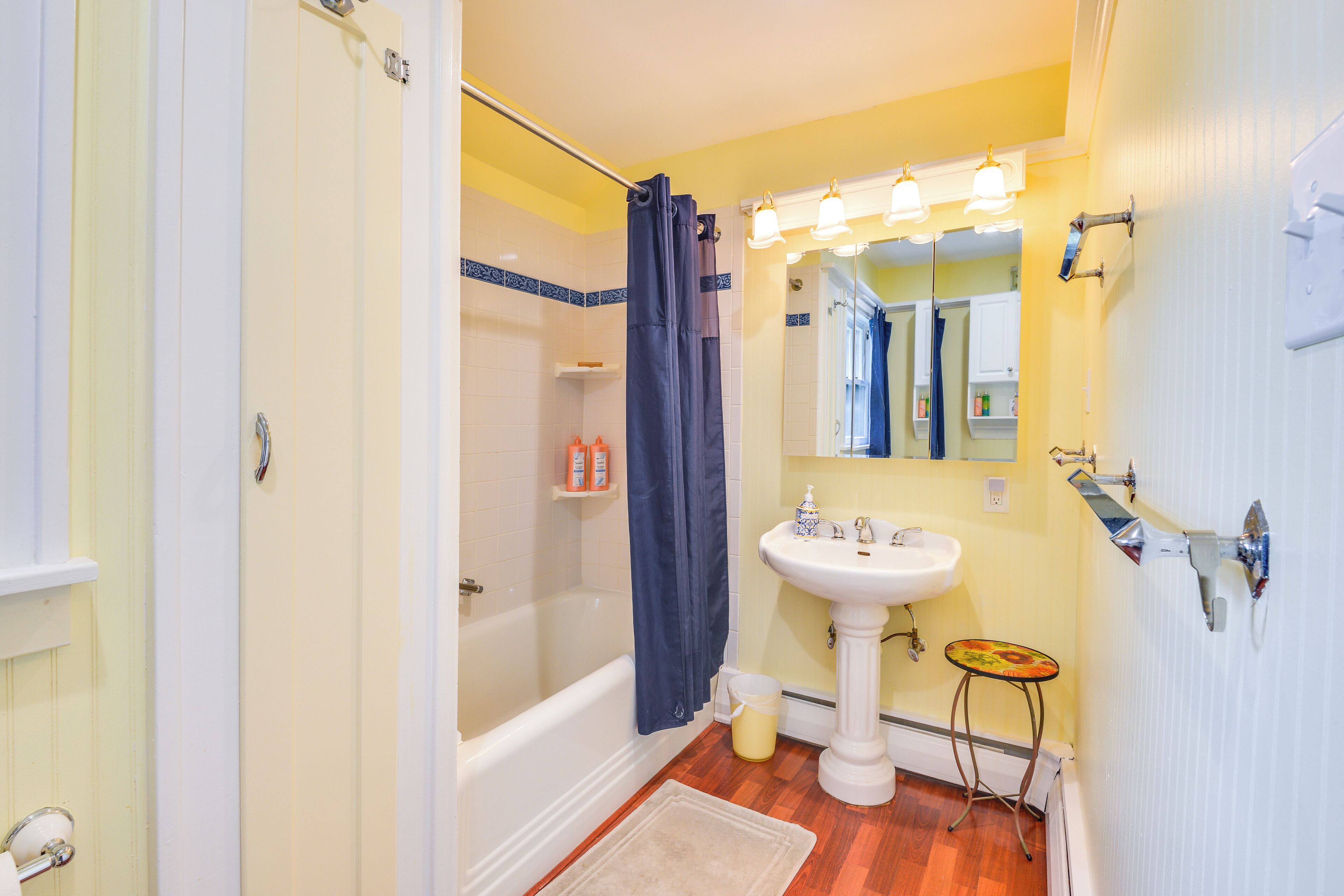 A bathroom with a bathtub, a sink, a mirror, and a shower curtain.