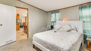 A bedroom with a bed, bedside table, and a ceiling fan. - 13 Mi to Okc: Edmond Home w/ Pool Access! (Edmond)