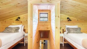 A wooden cabin with two beds, a skylight, and a small window. - 2 Mi to Dtwn: Spacious Gatlinburg Home w/ Hot Tub! (Gatlinburg)