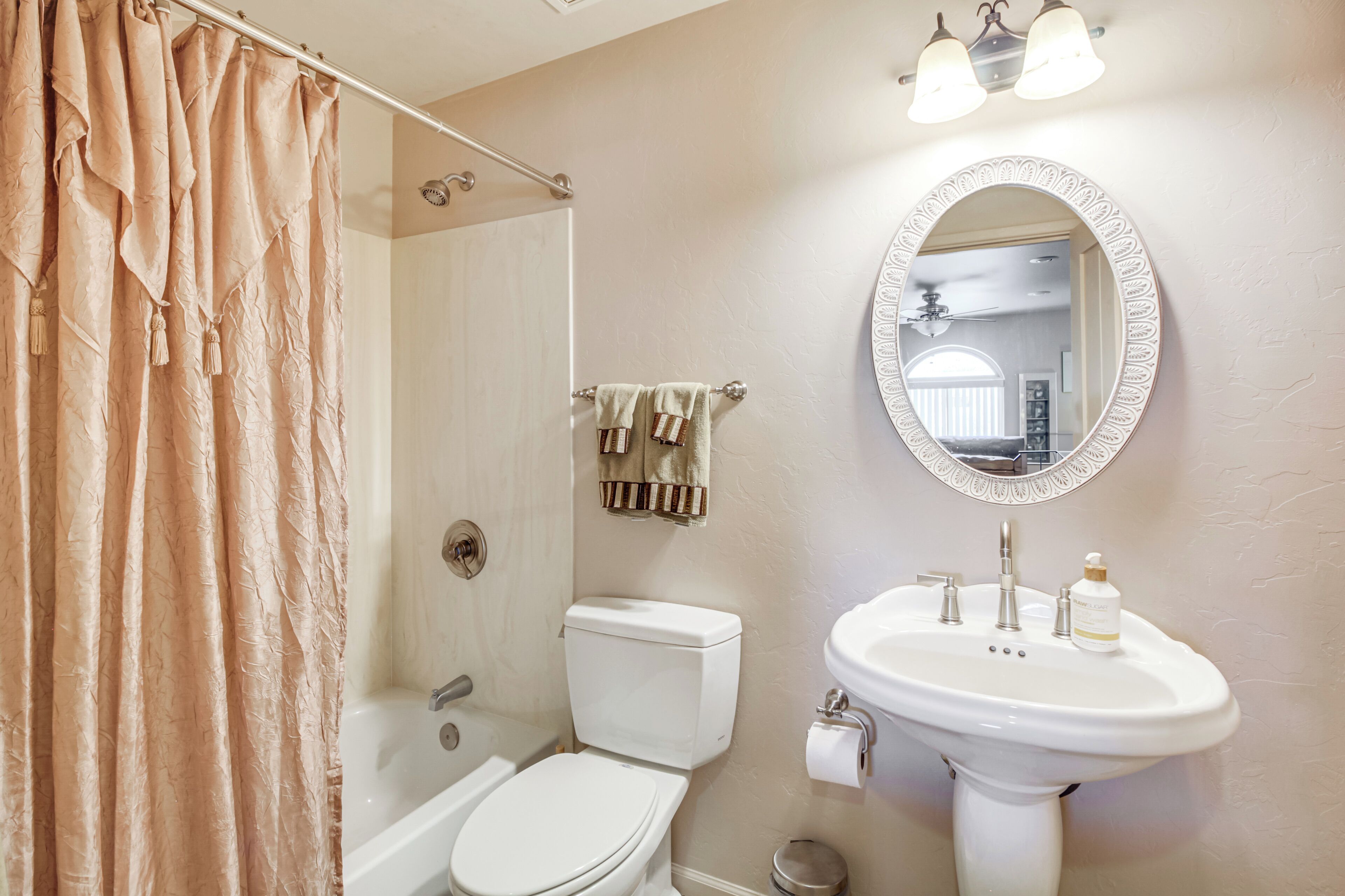 Baño con inodoro, lavamanos y cortina de ducha.