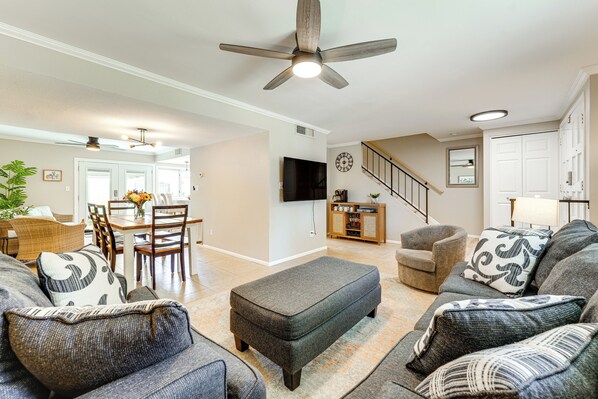 A spacious living room with a gray sofa, ottoman, and a dining area with chairs and a table. - 1.5 Mi to Old Town Scottsdale: Unit w/ Fenced Yard (Scottsdale)