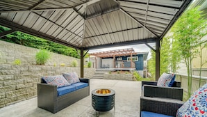 An outdoor patio with wicker furniture, a fire pit, and a covered area with a view of a house. - 2 Blocks to Beach Park: Cozy Seattle Townhome (Seattle)
