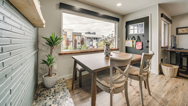 A dining area with a wooden table and chairs, a potted plant, and a window with a view of buildings outside. - 2 Blocks to Beach Park: Cozy Seattle Townhome (Seattle)
