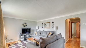 A living room with a grey sofa, a coffee table, a TV, and a patterned rug. - 8 Mi to Dtwn Cleveland: Quiet Home w/ Fenced Yard (Garfield Heights)