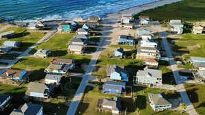 An aerial view of a coastal residential area with houses, roads, and a beach. - Walk to Beach: Ocean-view Home w/ Deck in Freeport (Freeport)