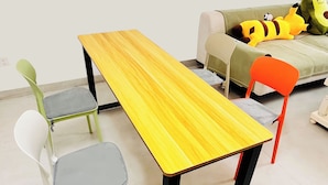Uma mesa de jantar com cadeiras, um sofá e uma mesinha com brinquedos.