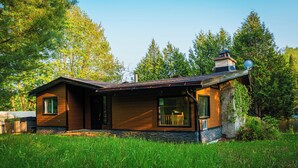 Een modern huis met een stenen fundering, houten gevel en een schotelantenne.