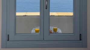 Une chambre avec vue sur la mer, accessible par une double porte.