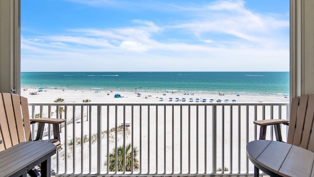 A balcony with a view of a beach and ocean.