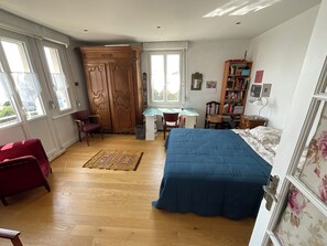 Une chambre à coucher comprenant un lit, un bureau, une chaise, une armoire et une bibliothèque.