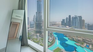Una habitación con un amplio ventanal que ofrece vistas a un paisaje urbano con edificios altos y una masa de agua.