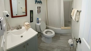 Une salle de bain avec un lavabo, des toilettes et une douche.