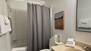A modern bathroom with a shower, toilet, and sink. - Unit 624 - Updated Condo (Winter Park)
