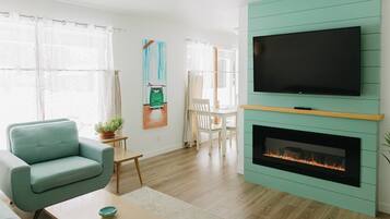TV connectée, cheminée, livres, chaîne hi-fi