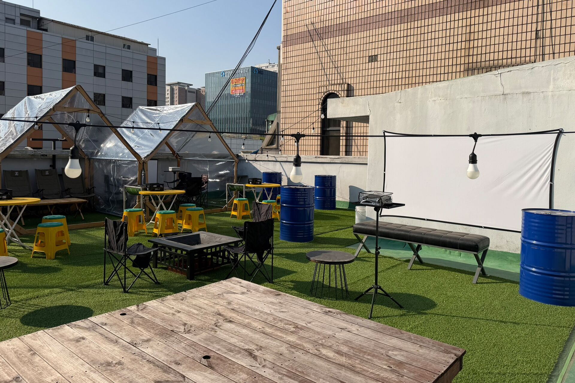 Une terrasse extérieure avec des tables, des chaises et un banc en bois.