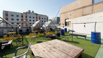 An outdoor seating area with tables, chairs, and umbrellas.