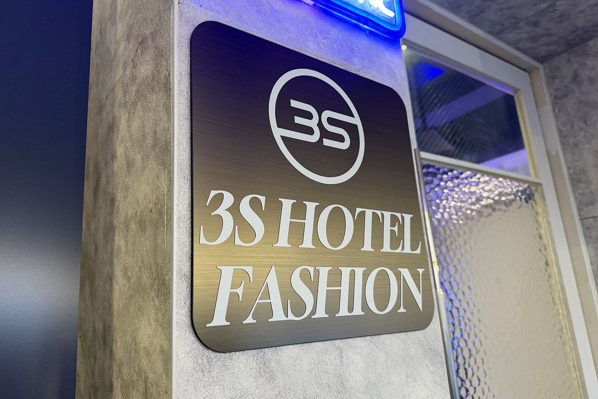 A sign for 3S Hotel Fashion with a metallic finish and illuminated letters.