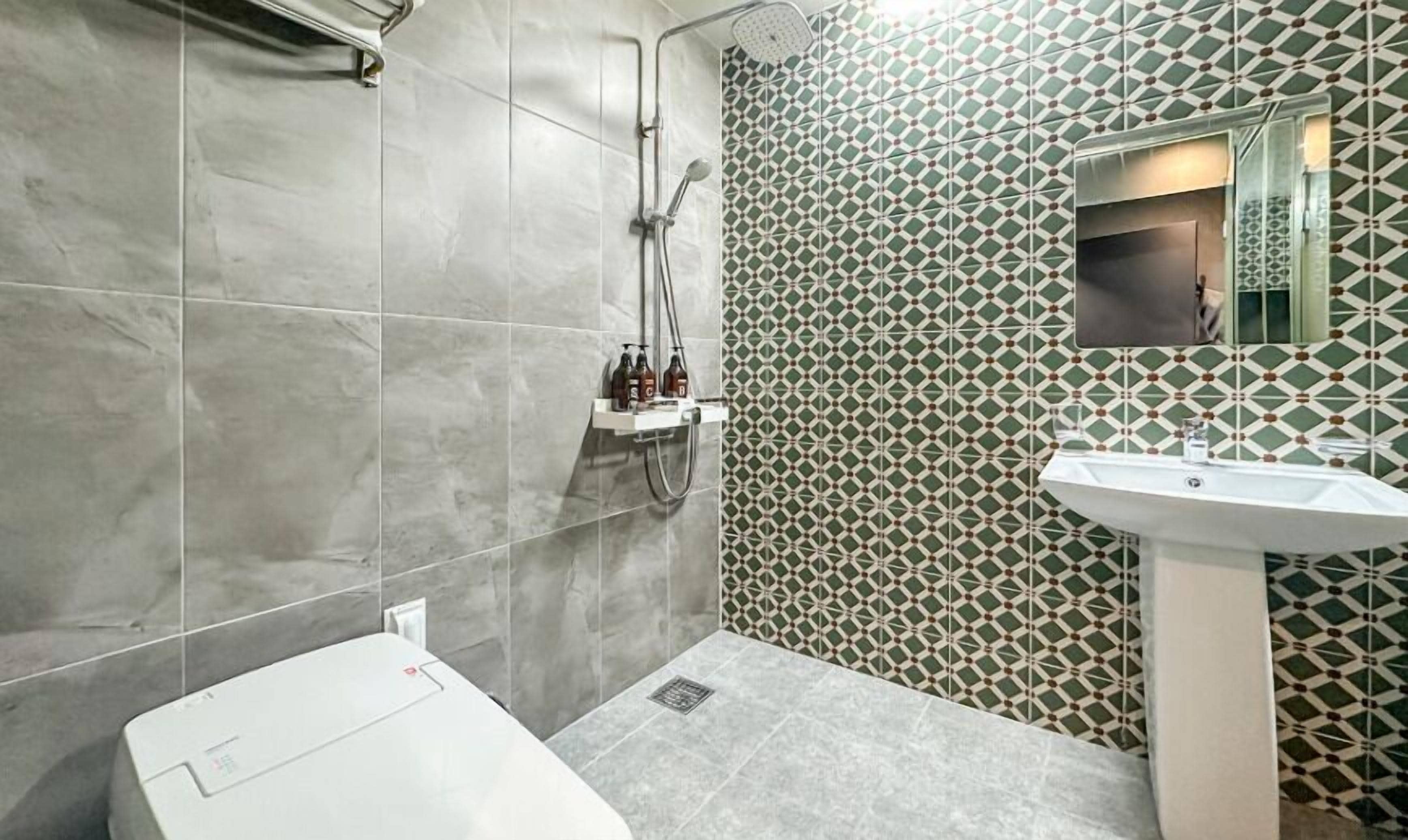 A bathroom with a shower, a sink, and a toilet.